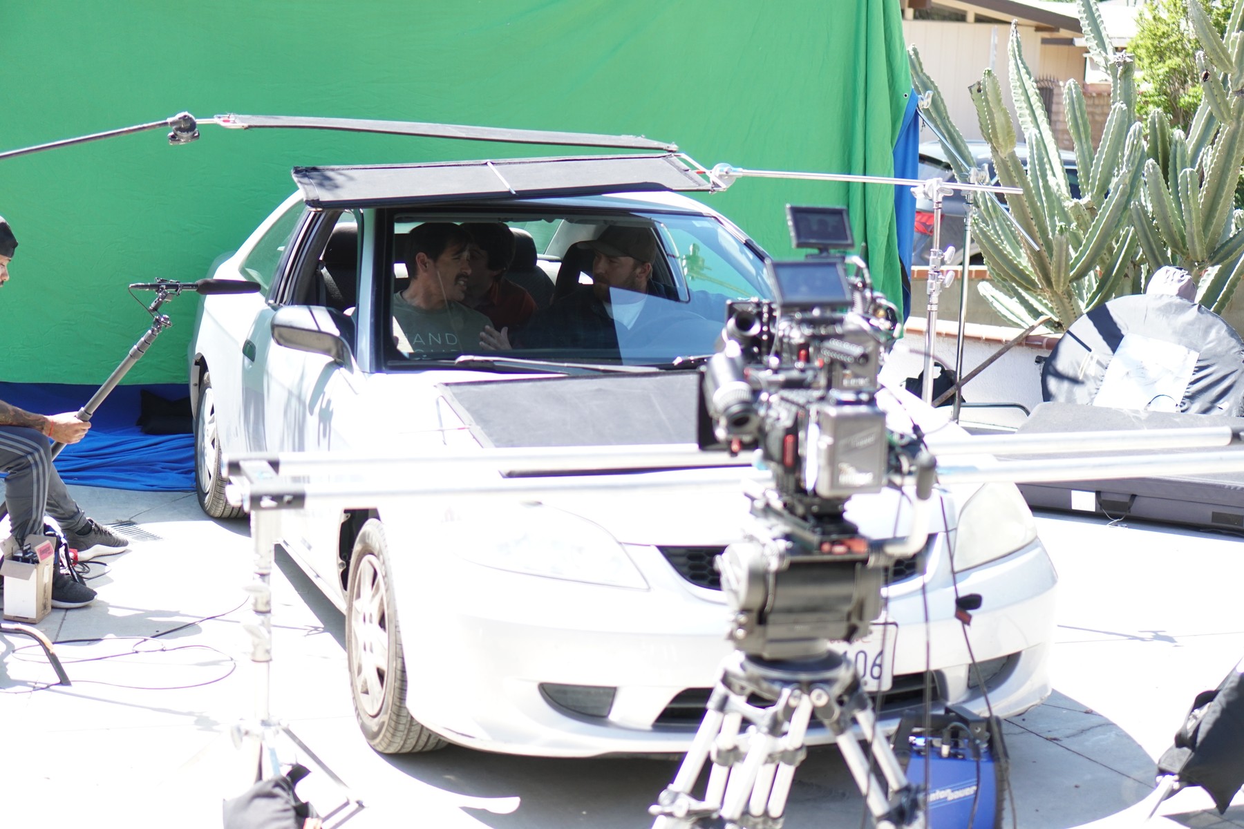 Performers, camera and rigging in the green-screen car setup